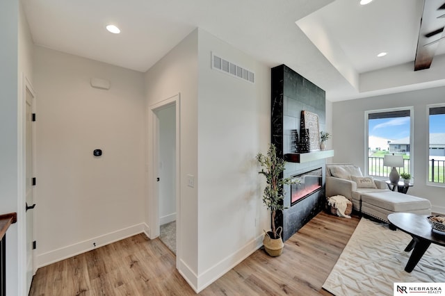 612 N 107th St, Lincoln, NE 68527 - living room with light wood-type flooring, a tiled fireplace, baseboards, and recessed lighting