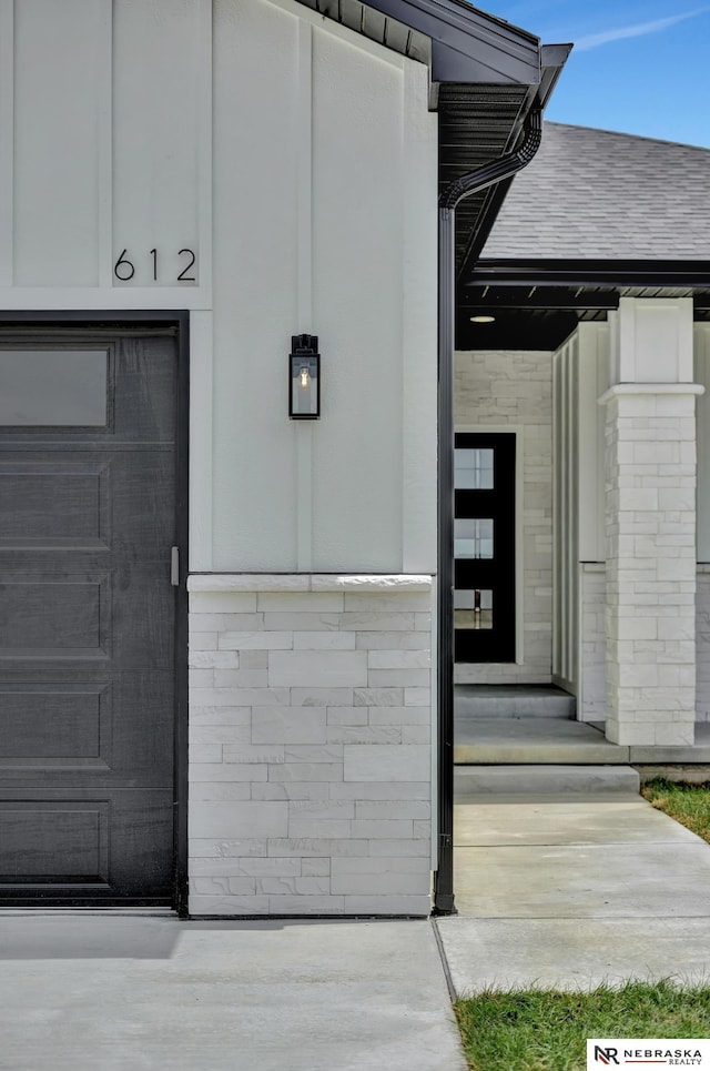 612 N 107th St, Lincoln, NE 68527 - view of exterior entry featuring a garage and stone siding