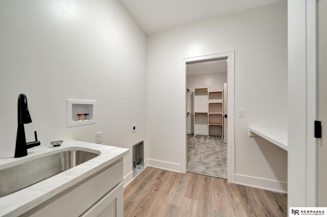 612 N 107th St, Lincoln, NE 68527 - laundry area with washer hookup, hookup for an electric dryer, light wood finished floors, baseboards, and cabinet space