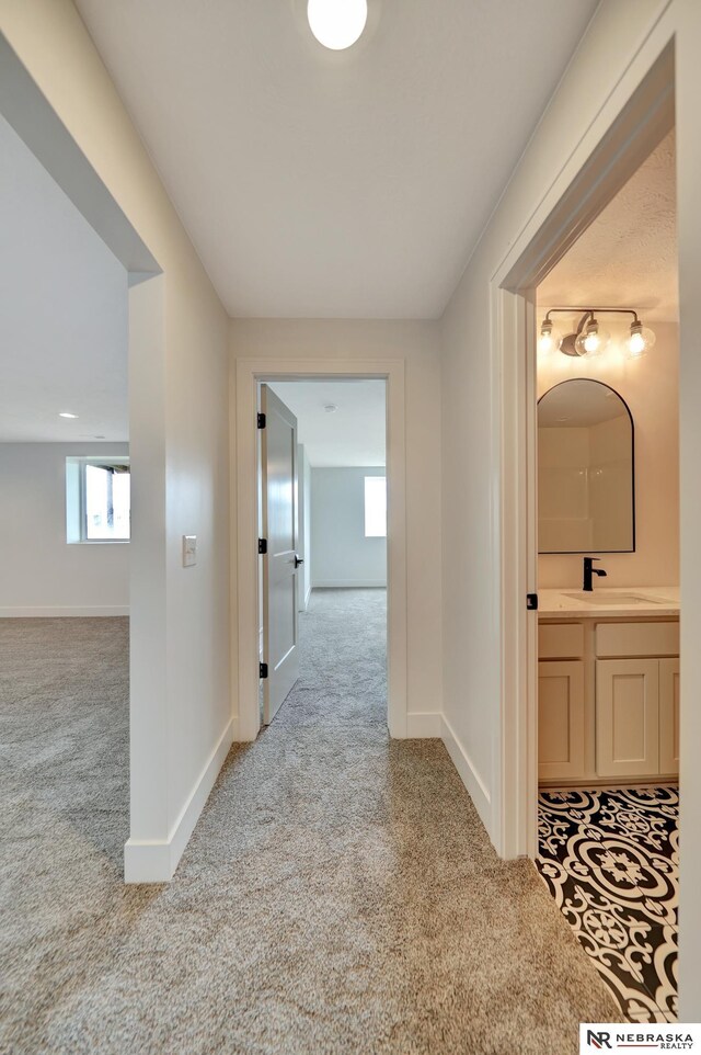 612 N 107th St, Lincoln, NE 68527 - hall with carpet, a sink, and baseboards