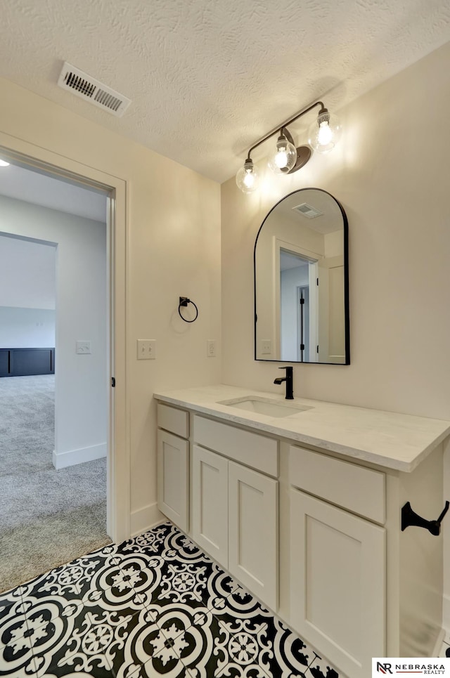 612 N 107th St, Lincoln, NE 68527 - bathroom with a textured ceiling, vanity, and rail lighting