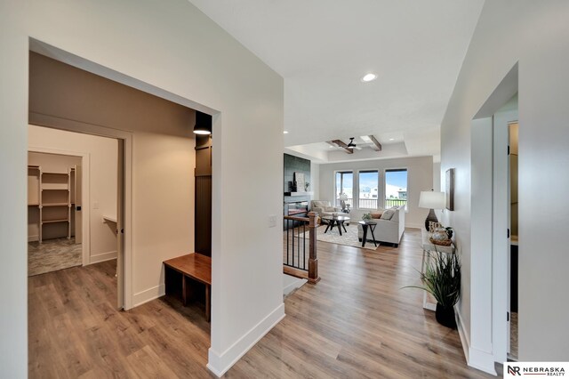 612 N 107th St, Lincoln, NE 68527 - hall featuring light wood-style flooring, baseboards, recessed lighting, a tray ceiling, and an upstairs landing