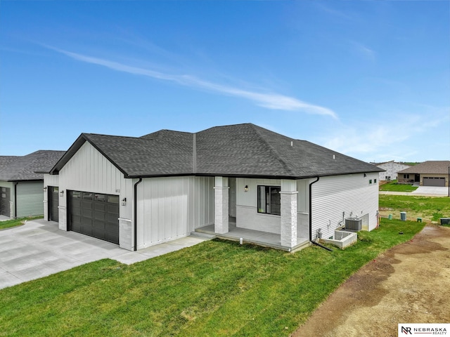 612 N 107th St, Lincoln, NE 68527 - view of front of property with a garage, roof with shingles, a front yard, and driveway