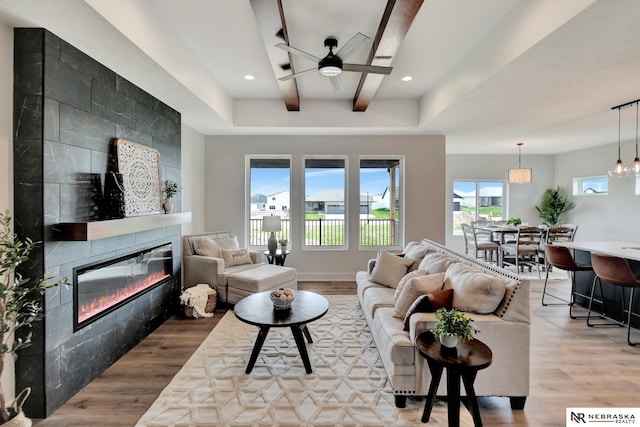 612 N 107th St, Lincoln, NE 68527 - living room featuring a tiled fireplace, wood finished floors, ceiling fan, recessed lighting, and beam ceiling