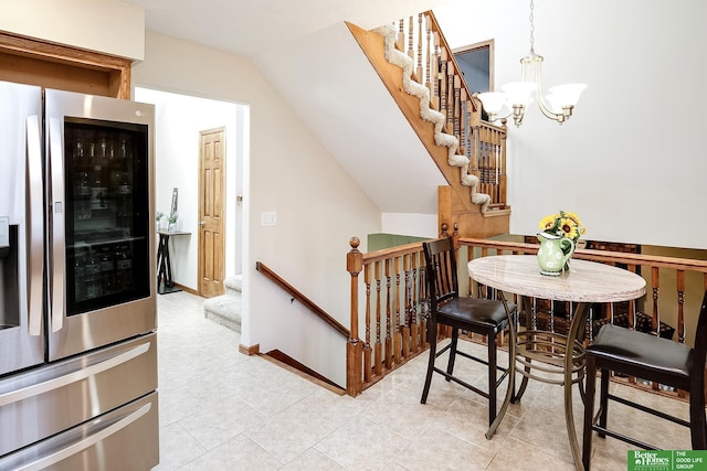 dining room featuring a chandelier, lofted ceiling, and light tile patterned flooring