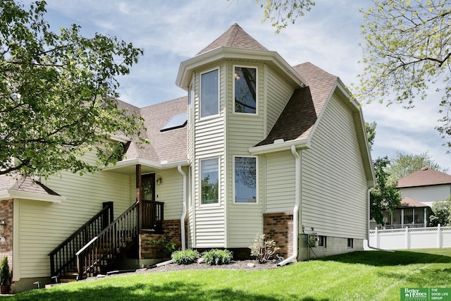 back of property featuring a shingled roof and brick siding