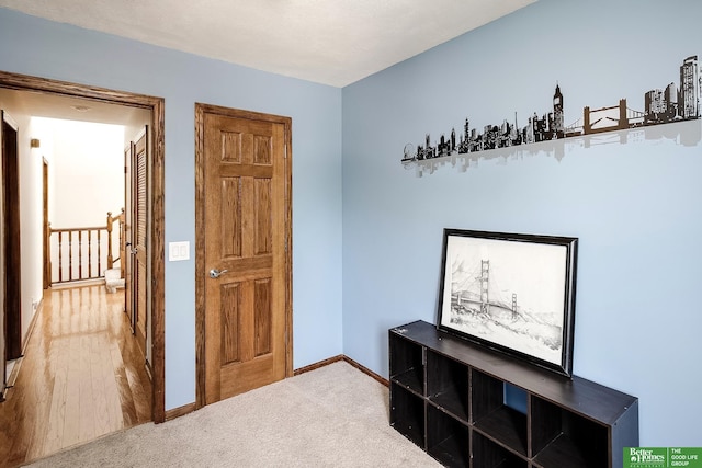 hallway featuring baseboards and carpet floors