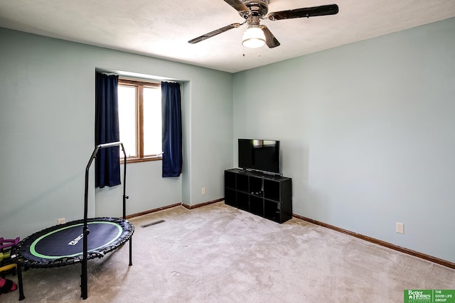 living area with ceiling fan, baseboards, and carpet floors