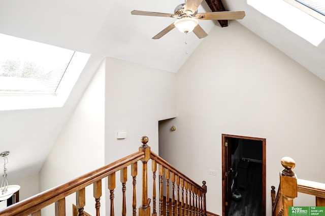 staircase featuring a skylight, high vaulted ceiling, and ceiling fan