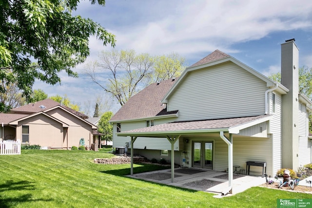 rear view of house with french doors, a chimney, central AC unit, a patio, and a lawn