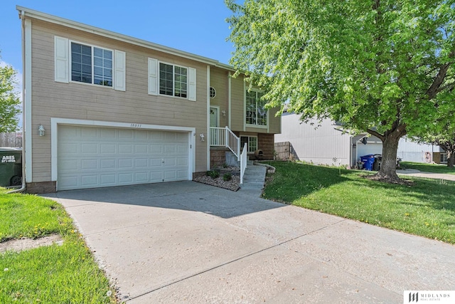 bi-level home featuring driveway, a front yard, and a garage