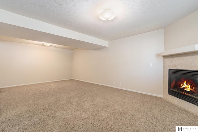 unfurnished living room with carpet, a tile fireplace, and baseboards