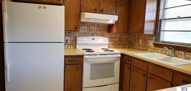 14930 Holmes St, Omaha, NE 68137 - kitchen with white appliances, under cabinet range hood, a sink, and plenty of natural light