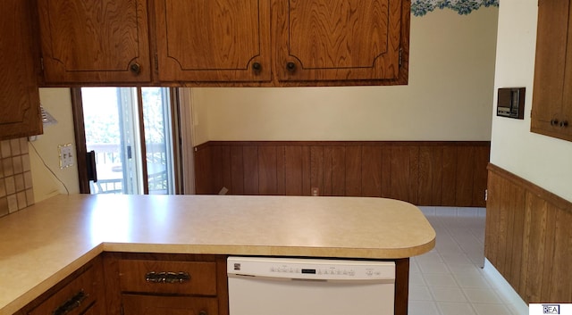 14930 Holmes St, Omaha, NE 68137 - kitchen featuring white dishwasher, a wainscoted wall, a peninsula, light countertops, and brown cabinetry