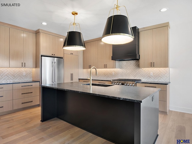 kitchen featuring a sink, light brown cabinets, high end fridge, custom range hood, and backsplash
