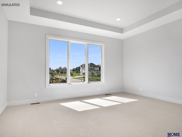 carpeted empty room with baseboards, recessed lighting, and a raised ceiling