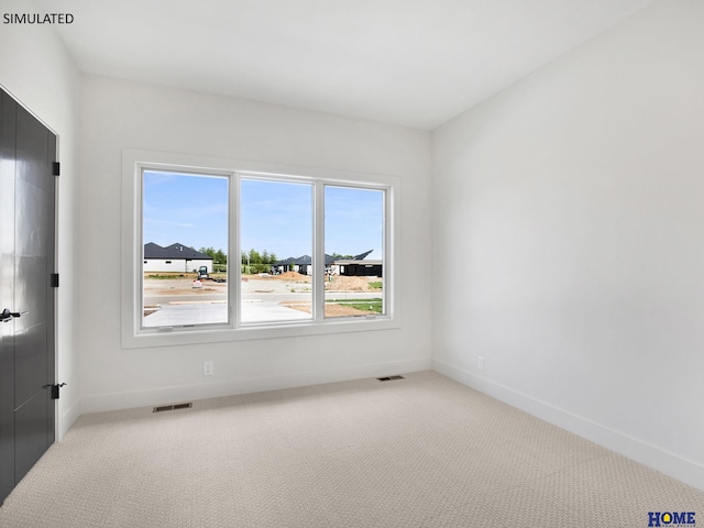 unfurnished room with light colored carpet and baseboards