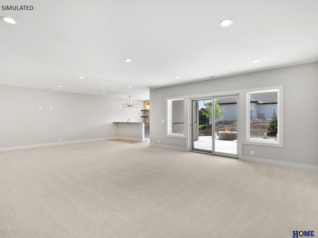 unfurnished living room with recessed lighting, light colored carpet, baseboards, and a chandelier