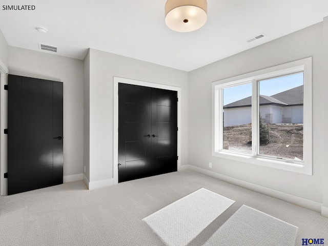 unfurnished bedroom featuring carpet floors, baseboards, and a closet
