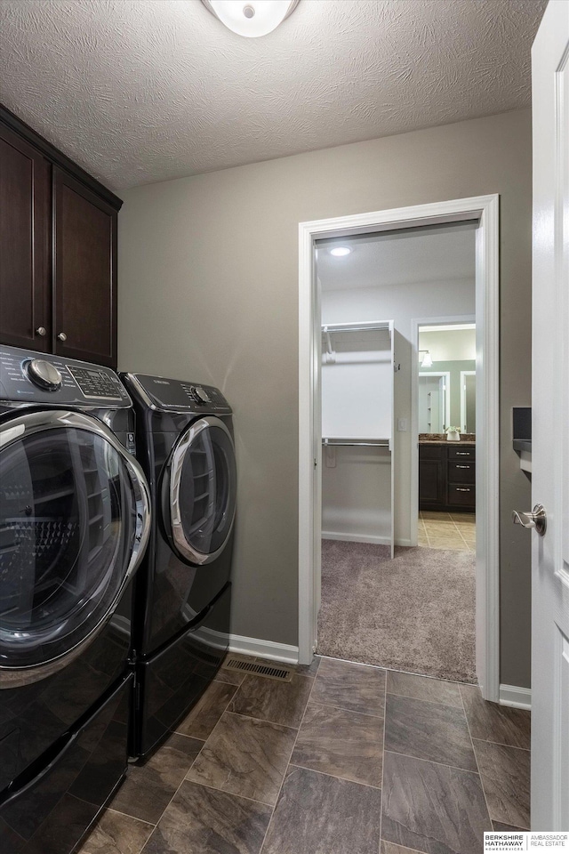 clothes washing area featuring cabinet space, separate washer and dryer, and baseboards