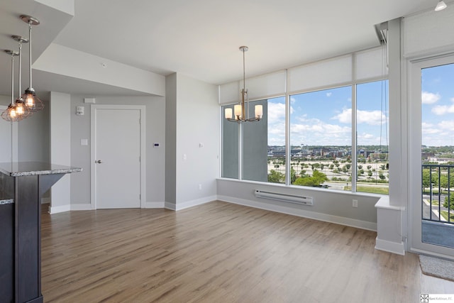444 Riverfront Plz Unit 801, Omaha, NE 68102 - unfurnished dining area featuring wood finished floors, a chandelier, and baseboards