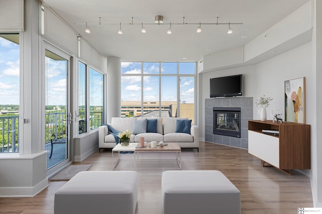 444 Riverfront Plz Unit 801, Omaha, NE 68102 - living area featuring wood finished floors, a tiled fireplace, and rail lighting