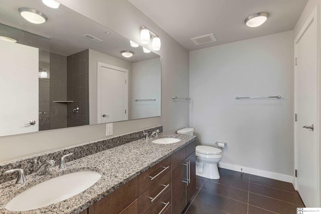 444 Riverfront Plz Unit 801, Omaha, NE 68102 - full bathroom with double vanity, toilet, baseboards, tile patterned floors, and tiled shower
