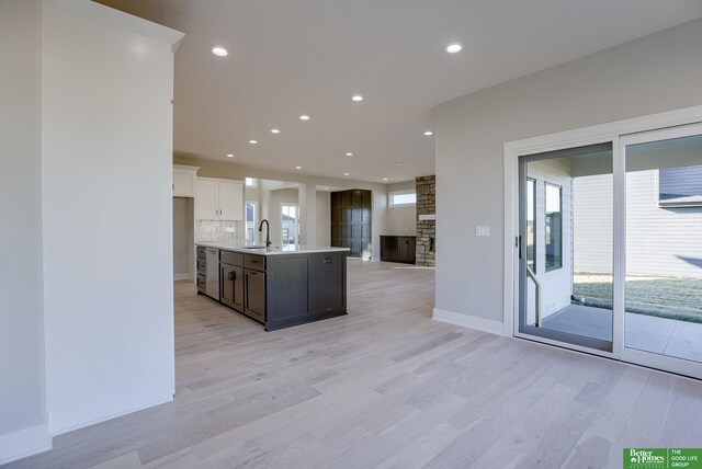 21108 Arlington St, Elkhorn, NE 68022 - kitchen with light wood-style flooring, open floor plan, light countertops, white cabinets, and recessed lighting
