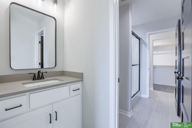 21108 Arlington St, Elkhorn, NE 68022 - bathroom featuring a shower stall, vanity, a spacious closet, baseboards, and tile patterned floors