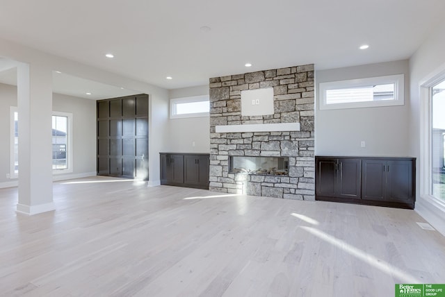 21108 Arlington St, Elkhorn, NE 68022 - unfurnished living room with a stone fireplace, plenty of natural light, wood finished floors, recessed lighting, and baseboards