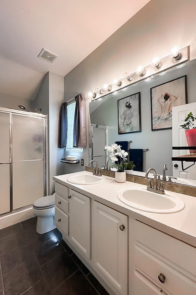 full bathroom featuring tile patterned flooring, a stall shower, double vanity, and toilet