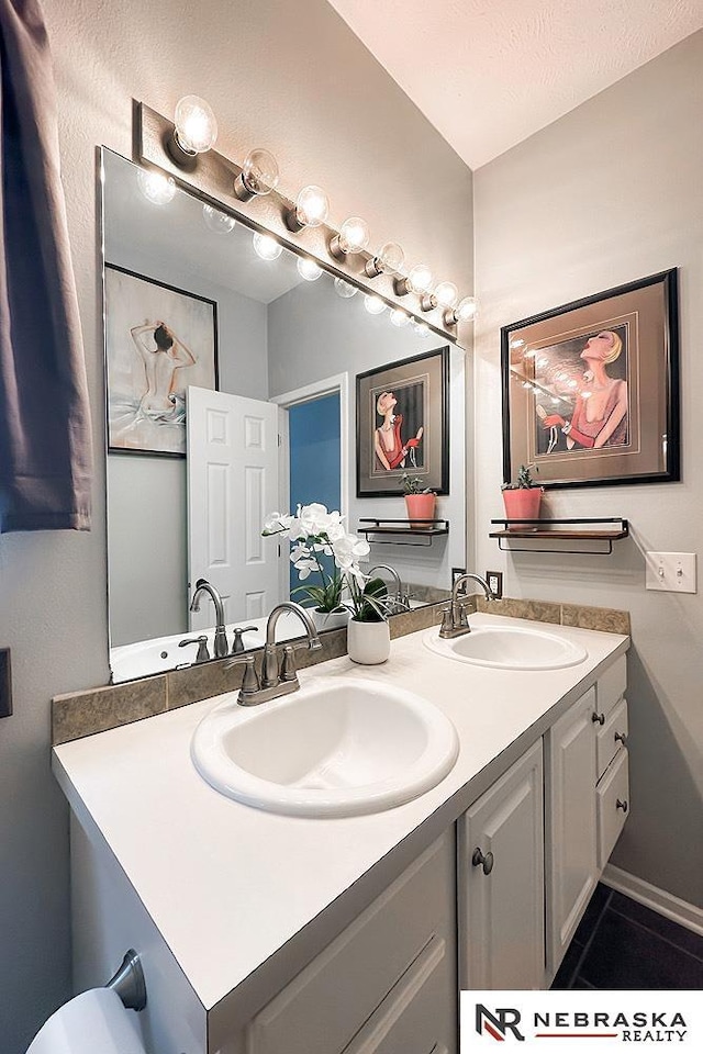 full bath with double vanity and tile patterned floors