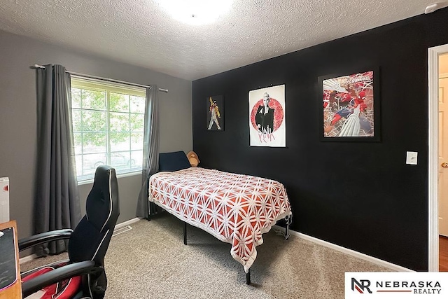 carpeted bedroom with baseboards, a textured ceiling, and a desk