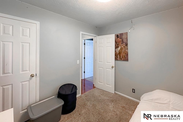 carpeted bedroom with baseboards and a textured ceiling