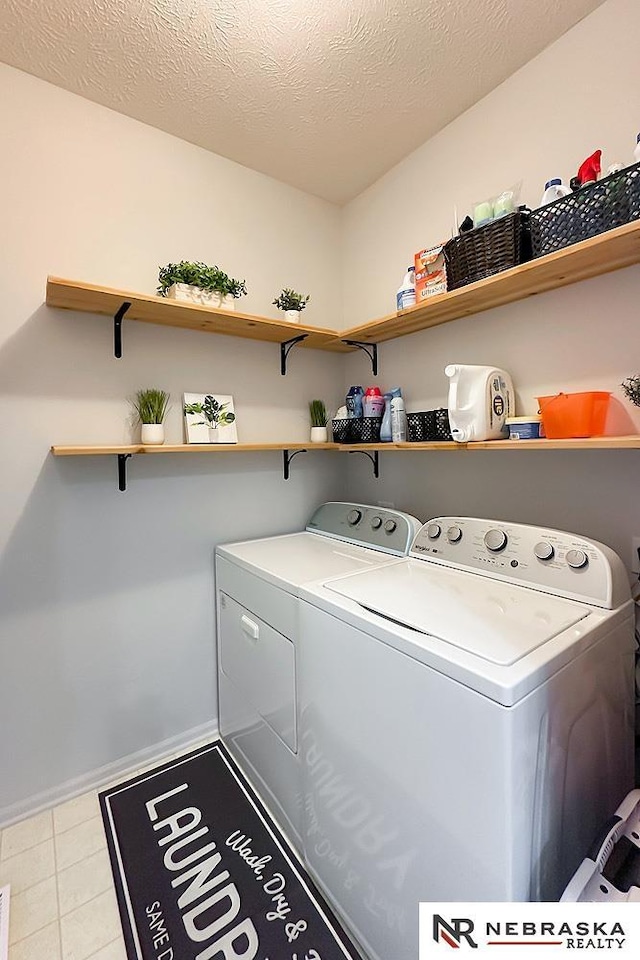 washroom with independent washer and dryer, baseboards, and tile patterned flooring