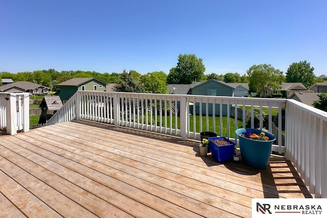 wooden deck featuring a residential view and a yard