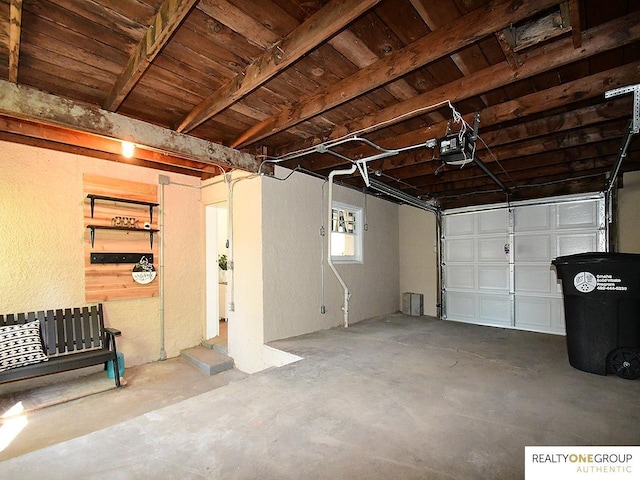 garage featuring a garage door opener, a textured wall, and wooden ceiling