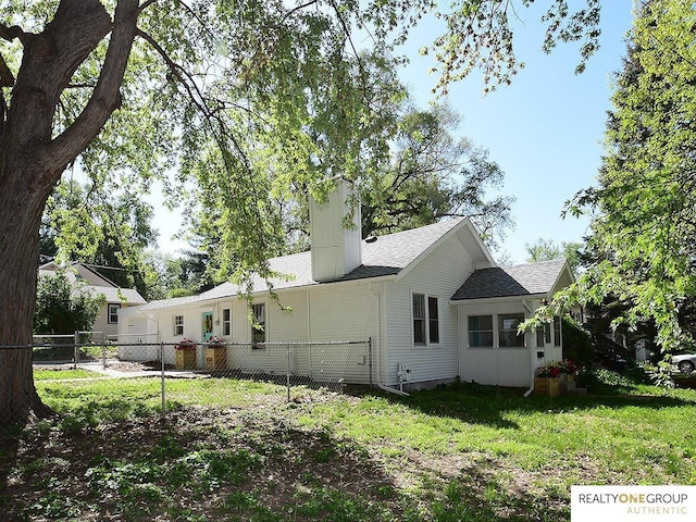 back of property featuring a shingled roof and a chimney
