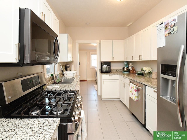 4210 S 21st St, Omaha, NE 68107 - kitchen with stainless steel appliances, a sink, light tile patterned floors, white cabinets, and light stone countertops