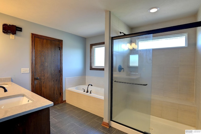bathroom with a stall shower, a garden tub, and double vanity