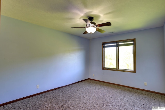spare room with ceiling fan, carpet flooring, and baseboards