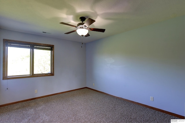 spare room featuring ceiling fan, carpet flooring, and baseboards