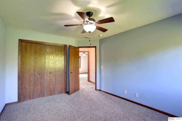 unfurnished bedroom featuring carpet flooring, baseboards, and a closet