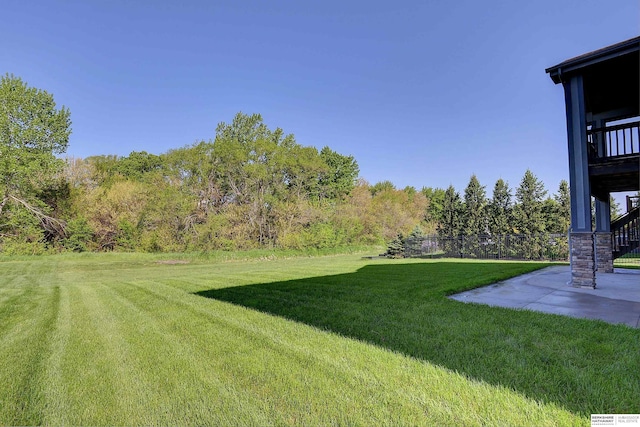 view of green lawn featuring a patio and stairs