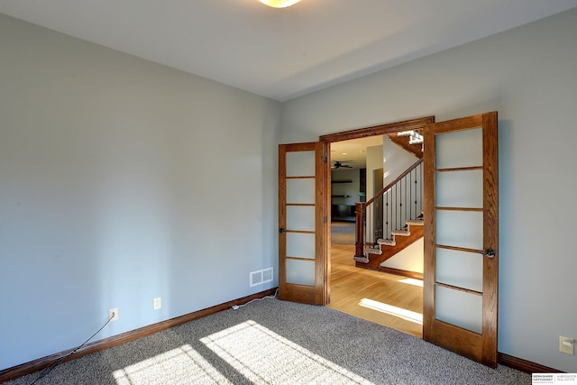 empty room featuring baseboards, stairs, carpet flooring, and ceiling fan