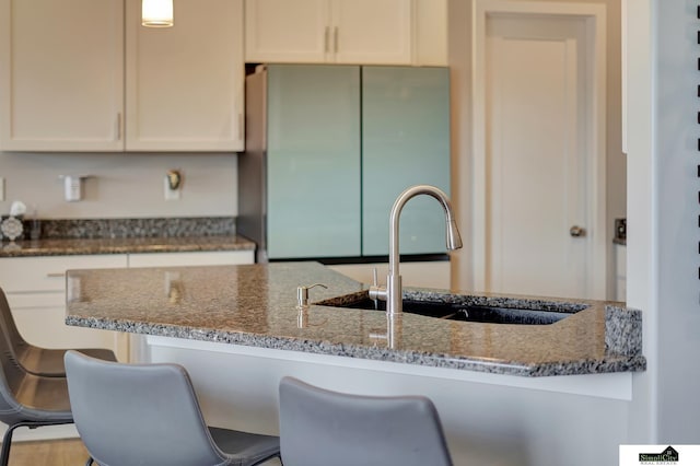 9551 N 144th St, Waverly, NE 68462 - kitchen featuring fridge, a sink, dark stone countertops, and white cabinetry