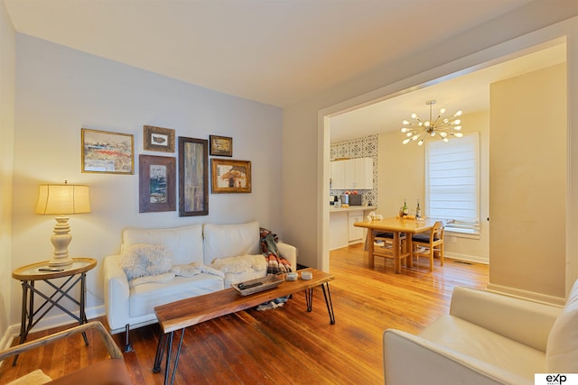 2939 Martha St, Omaha, NE 68105 - living room featuring a chandelier, light wood-style flooring, and baseboards