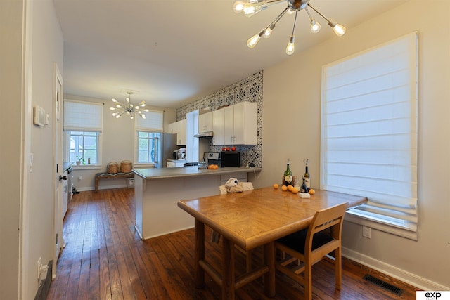 2939 Martha St, Omaha, NE 68105 - dining area with a chandelier, dark wood-style floors, and baseboards