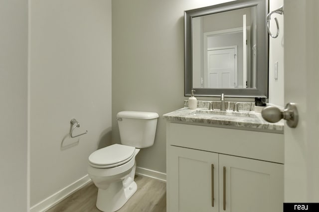 4406 Barksdale Dr, Bellevue, NE 68123 - half bath with wood finished floors, baseboards, vanity, and toilet