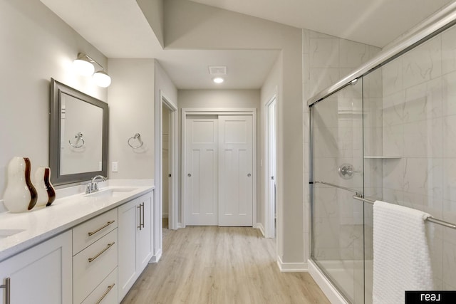 4406 Barksdale Dr, Bellevue, NE 68123 - bathroom with wood finished floors, a shower stall, double vanity, and baseboards